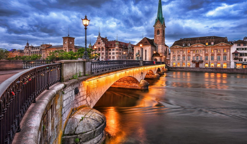 zurich limmat river bridge old town church clocktower evening reflection switzerland